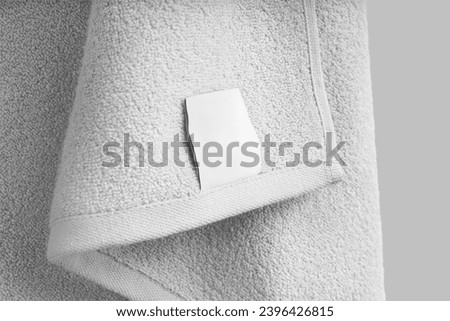 Mockup of a textured white towel with a label, close-up, for design, branding. Product photography. Home decor for bathroom. Terry towelette template for wiping, isolated on background.