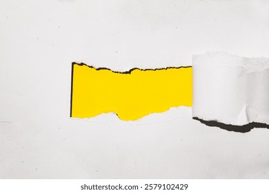 Mockup of a torn white paper revealing a vibrant yellow background. Perfect for showcasing your brand, logo, or text.