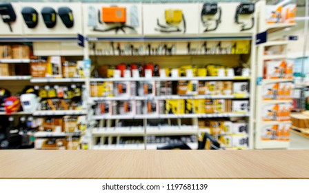 Mockup. Welding equipment. Shop with a variety of electrical equipment for welding. Defocused, blurred image. In the foreground is the top of a wooden table, counter.