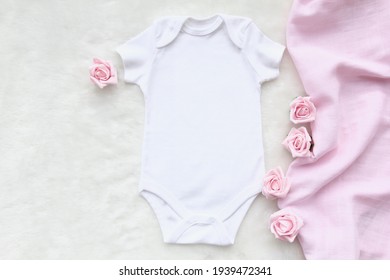 Mockup Of White Baby Bodysuit Shirt With Pink Rose And Pink Blanket On White Cotton Background. Design Bodysuit Template