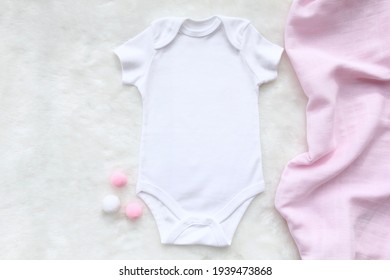 Mockup Of White Baby Bodysuit Shirt With Pink - White Cotton Balls And Pink Blanket On White Cotton Background. Design Bodysuit Template