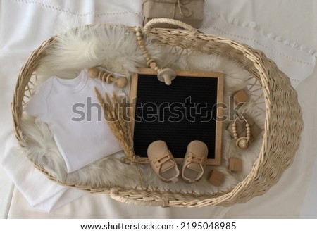 Mockup of white baby bodysuit shirt with basket, Letter Board Announcement .Pregnancy announcement background with blurred . Selective focus