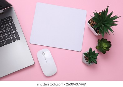 Mockup of white blank computer mouse pad with props, mouse and laptop, pink background. Top view. Flat lay