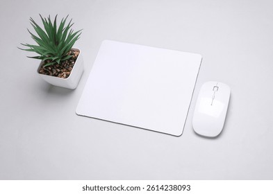Mockup of white blank computer mouse pad or mat with wireless mouse on gray background