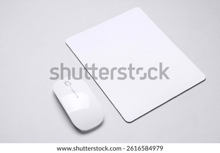 Mockup of white blank computer mouse pad or mat with wireless mouse on gray background