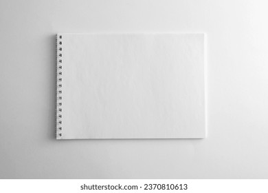 Mockup of white book, notebook, copybook, blank notepad cover with metal spiral template on white background. Layout mock up ready for your design preview.