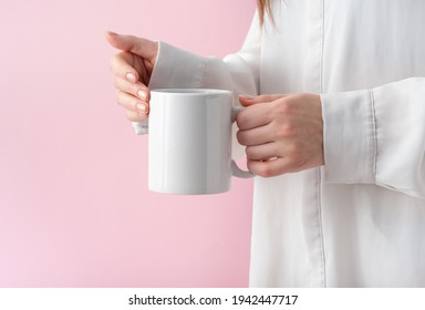 Mockup White Coffe Cup Or Mug In Female Hands On Pink Background With Copy Space. Blank Template For Your Design, Branding, Business. Woman In Shirt Casual Style. Real Photo.