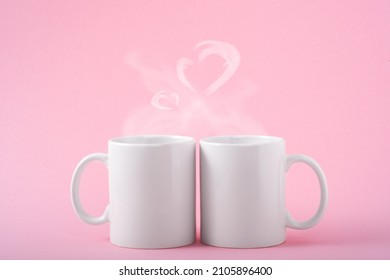 Mockup white coffe two cups or mug on a pink background with copy space. Blank template for your design, branding, business. Real photo. Hot drink steam in the form of hearts