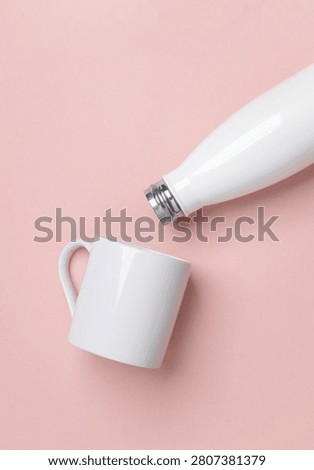 Mockup of white empty ceramic cup and thermos bottle on pink background                    