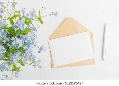 Mockup White Greeting Card And Envelope With Blue Flowers And Light Background