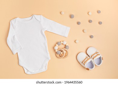 Mockup of white infant bodysuit made of organic cotton with eco friendly baby accessories. Onesie template for brand, logo, advertising. Flat lay, top view