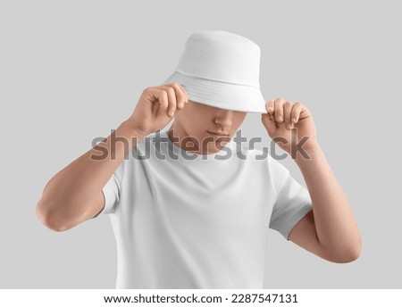 Mockup of white panama on posing guy in t-shirt, sun hat, blank accessory for design, print, brand, advertising. Fashion unisex headgear template, isolated on background. Spring, summer headdress