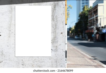 Mockup white paper or white sticker poster displayed on a sidewalk wall. Promotion information for marketing announcements and details - Shutterstock ID 2164678099