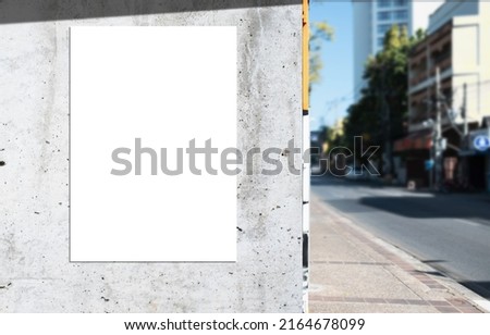 Mockup white paper or white sticker poster displayed on a sidewalk wall. Promotion information for marketing announcements and details