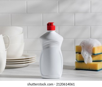 Mockup white plastic with dishwashing gel with shadows and yellow sponges with foam on top  - Shutterstock ID 2120614061