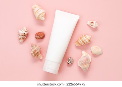 Mockup White Squeeze Bottle Cosmetic Tube And Sea Shells A Lot On Pink Background. Body Cream, Gel, Skincare, Sunscreen, Moisturizer. Front Top View, Blank Tube, Template, Toothpaste, Flat Lay