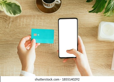 Mockup Of A Woman Holding A Phone And A Credit Card On The Table. Blank Screen To Insert Design. E-commerce Concept