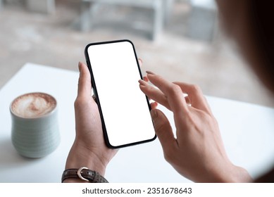 Mockup, woman's hand holding using mobile phone at coffee shop with copy space, white blank screen for text, mobile app design and advertising, online marketing