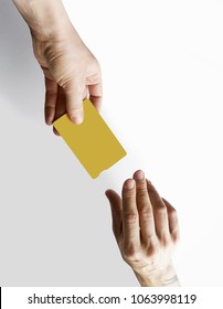 Mockup Of Yellow Color Credit Card Give Male Hands On Empty White Desk Background. Business Mock-up Background For Message Writing.Top View. Vertical