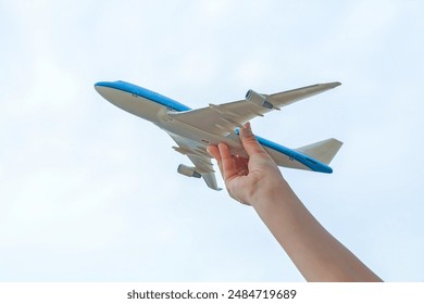 Model of an airplane in the hand of a small child against the sky - Powered by Shutterstock