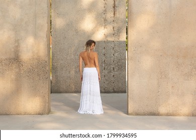 model between concrete blocks looking over her shoulder 