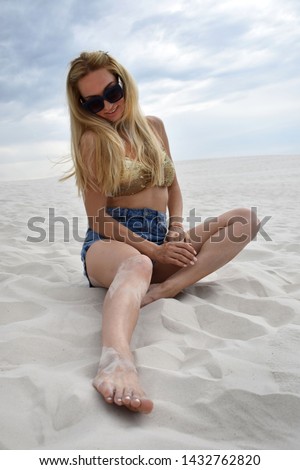 
Model blonde sitting on the sand