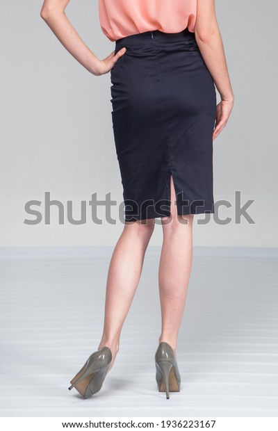 Model in a blue skirt and a light blouse on a\
light background.