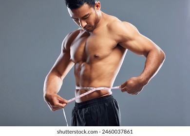 Model, body and measurement for waist, weight loss and management for fat control or bmi and diet wellness. Fitness man, sports athlete or guy with tape measure for muscle goals on studio background - Powered by Shutterstock