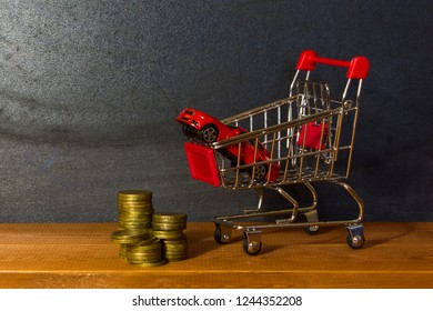 Model Car In  Grocery Cart On Background Of Drawing Boards And Coins. Concept Of Leasing, Auto Loan, Auto Insurance, Taxes, Car Purchase