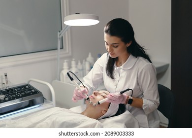 Model with closed eyes and hand's of doctor. Rejuvenating facial treatment. Model getting lifting therapy massage in a beauty SPA salon. Cosmetological clinic, procedure. - Shutterstock ID 2089003333
