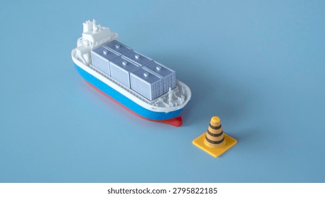 Model container ship approaching a small traffic cone signaling maritime delays or shipping route restrictions