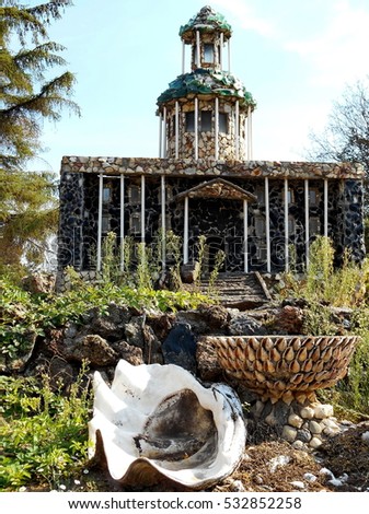 A model courthouse made from local Central Oregon rocks and large shells at Peterson's Rock Garden on a sunny day.