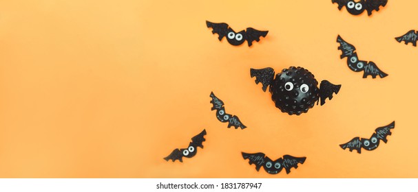 Model of Covid virus in the shape of a bat with flying bats in the background. Scariest hero in Halloween 2020. Halloween during Corona virus global pandemic concept. Wide banner. Copy space
