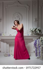 Model In A Crimson Dress In A Stylish Interior With Space For Text.