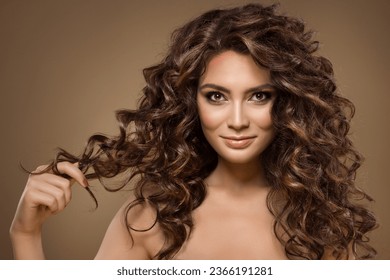 Model with Curly Hair. Beauty Woman with Long Wavy Hairstyle pulling Lock of brown Hair. Beautiful Girl with natural Makeup showing Curls - Shutterstock ID 2366191281