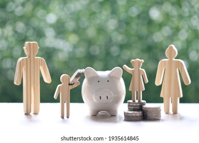 Model Family With Piggy Bank And Stack Of Coins Money On Natural Green Background,Save Money For Prepare In Future And Family Finance Concept