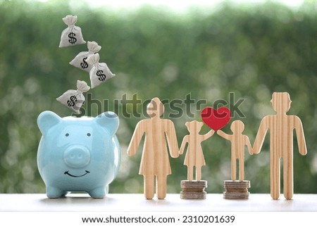 Model family with piggy bank and stack of coins money on natural green background,Save money for prepare in future and family finance concept