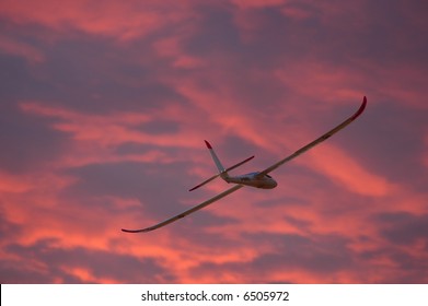 Model glider plane flying at sunset