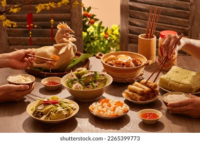 Model hands with Tet tray. Full of traditional dishes. Chinese new year festival table with asian food. Front view.