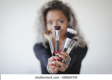 Model Holding Makeup Brushes