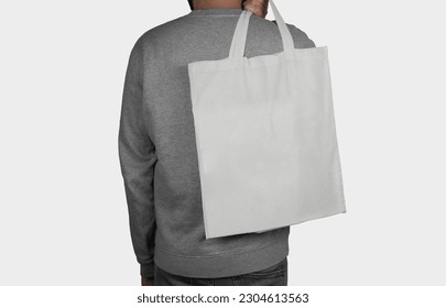 Model holding a tote bag on his back