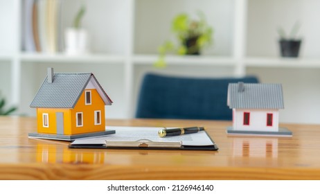 Model Homes, Home Loans, Home Equity Loans Home Model Insurance And A Pen On The Table To Plan To Refinance Home Loans Or Deposit Interest Rates Business And Finance Concept