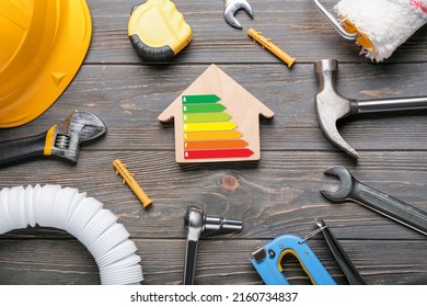 Model of house with builder's supplies and energy efficiency rating on wooden background - Powered by Shutterstock