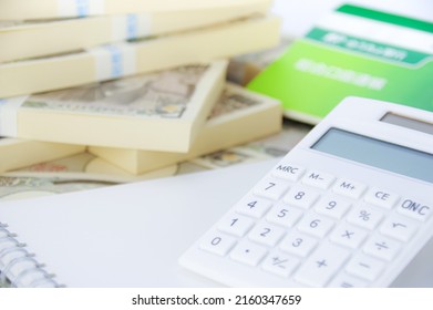 A Model Of A House, A Bunch Of Japanese Yen Bills, And A Japanese Savings Passbook