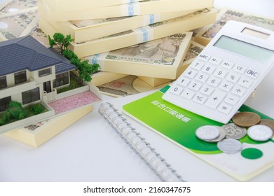 A Model Of A House, A Bunch Of Japanese Yen Bills, And A Japanese Savings Passbook