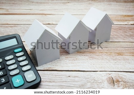 Model House and calculator on wooden background, realestate concept