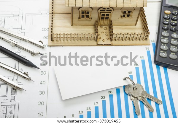Model house, construction plan for house building,\
keys, blank business card, divider compass. calculator. Real Estate\
Concept. Top view.