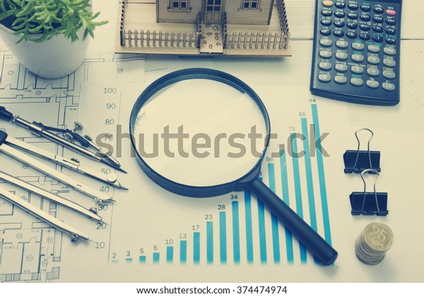Model house, construction plan for house building,\
magnifying glass, divider compass. calculator. Real Estate Concept.\
Top view.