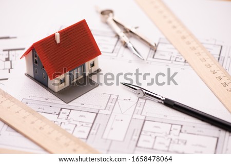 A model house on blueprints with keys to the new home Close up