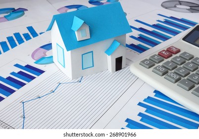 Model  house for sale and graphs. Real estate concept. - Shutterstock ID 268901966
